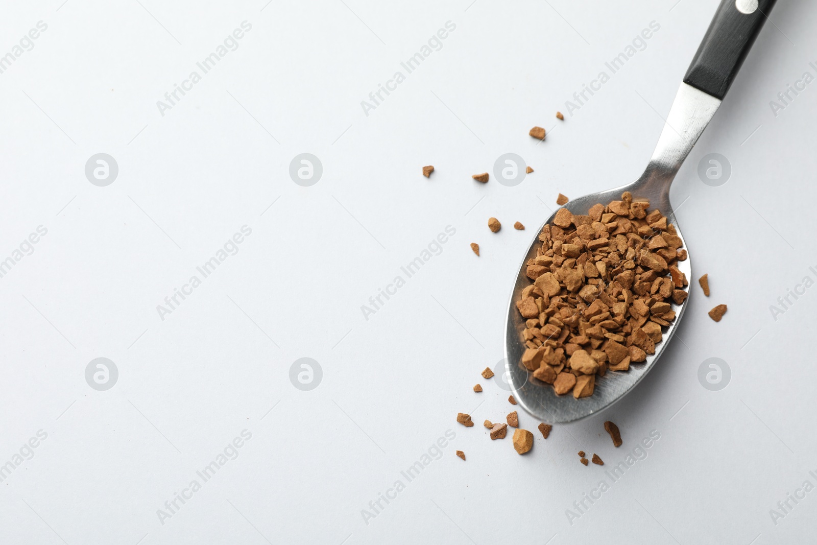Spoon with granulated instant coffee on white background, top view. Space for text Photo of Spoon with granulated instant coffee on white background, top view. Space for text