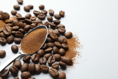 Photo of Spoon with instant coffee powder and beans on white background, closeup. Space for text