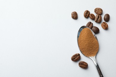 Photo of Spoon with instant coffee powder and beans on white background, flat lay. Space for text