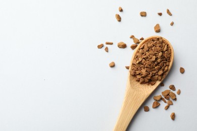 Photo of Spoon with granulated instant coffee on white background, top view. Space for text