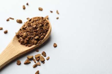 Photo of Spoon with granulated instant coffee on white background, closeup. Space for text