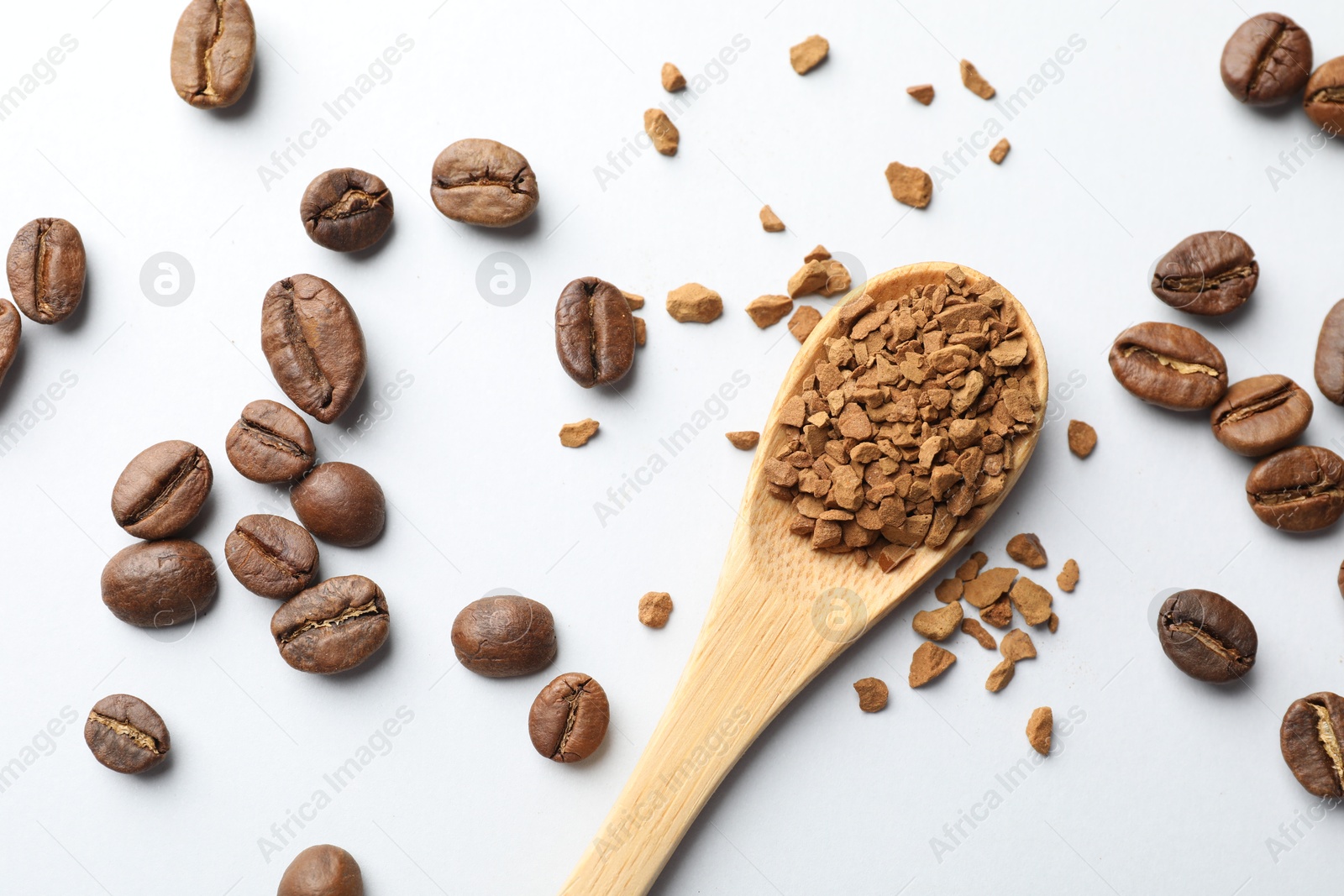 Spoon with instant coffee powder and beans on white background, flat lay Photo of Spoon with instant coffee powder and beans on white background, flat lay