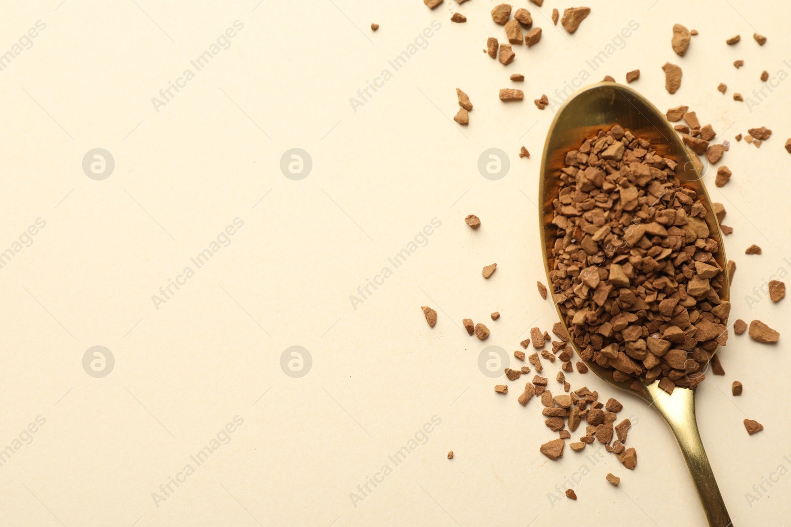Spoon with granulated instant coffee on beige background, top view. Space for text Photo of Spoon with granulated instant coffee on beige background, top view. Space for text