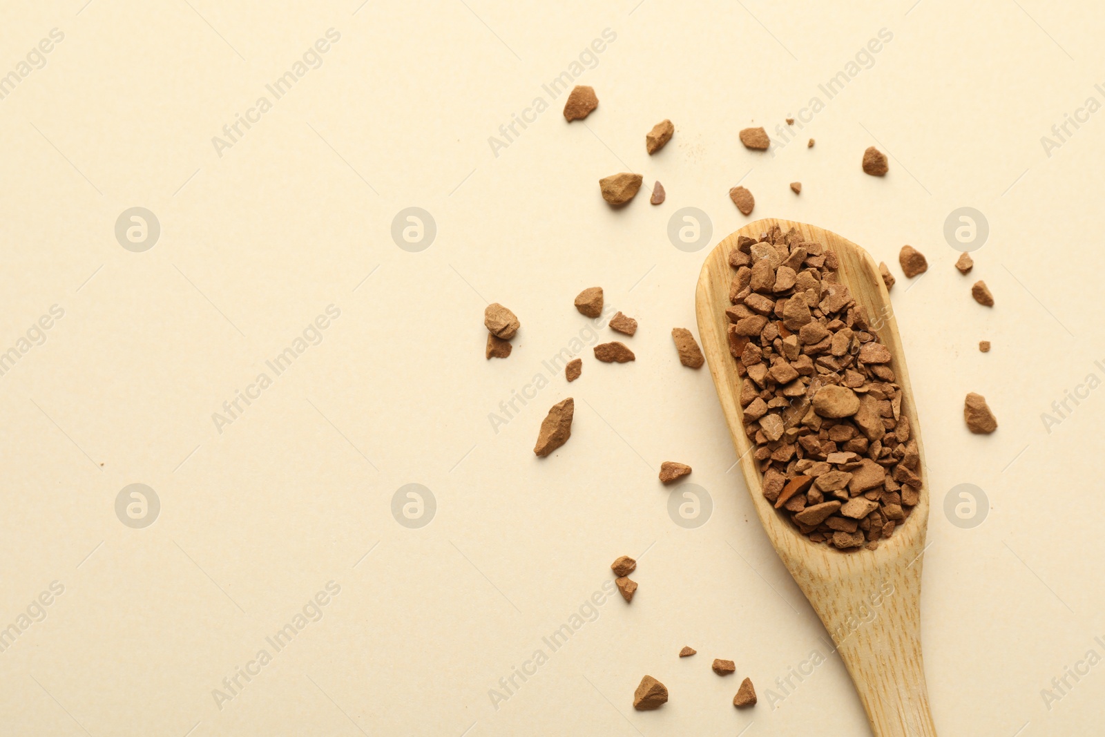 Spoon with granulated instant coffee on beige background, top view. Space for text Photo of Spoon with granulated instant coffee on beige background, top view. Space for text