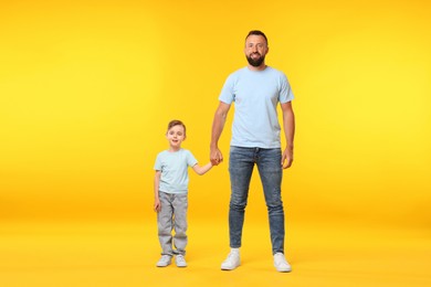 Photo of Family. Happy father and his son on yellow background