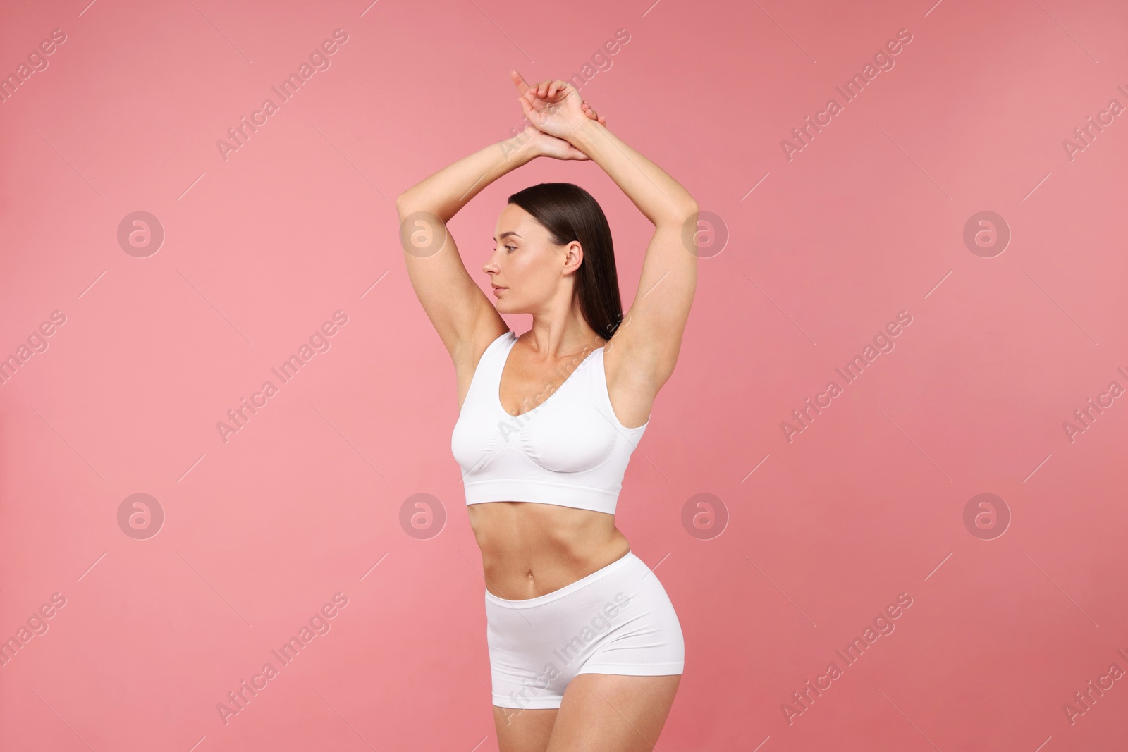 Fit woman with perfect body on pink background Photo of Fit woman with perfect body on pink background