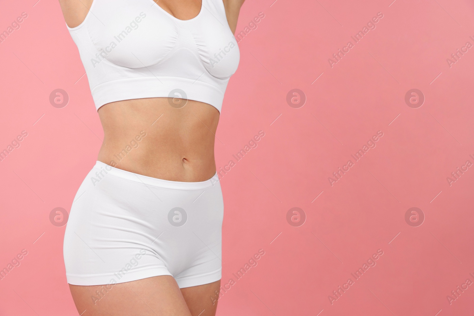 Fit woman with perfect body on pink background, closeup. Space for text Photo of Fit woman with perfect body on pink background, closeup. Space for text