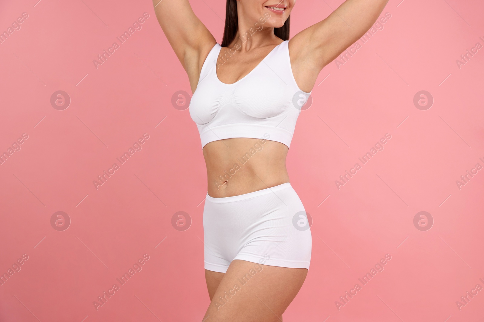 Photo of Fit woman with perfect body on pink background, closeup