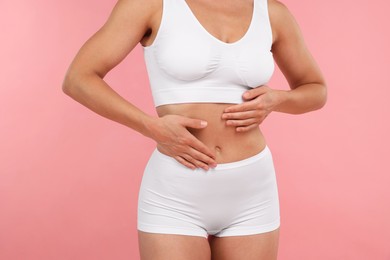 Photo of Fit woman with perfect body on pink background, closeup