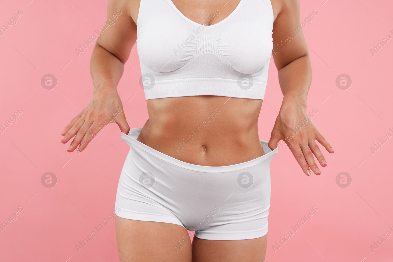 Fit woman with perfect body on pink background, closeup Photo of Fit woman with perfect body on pink background, closeup
