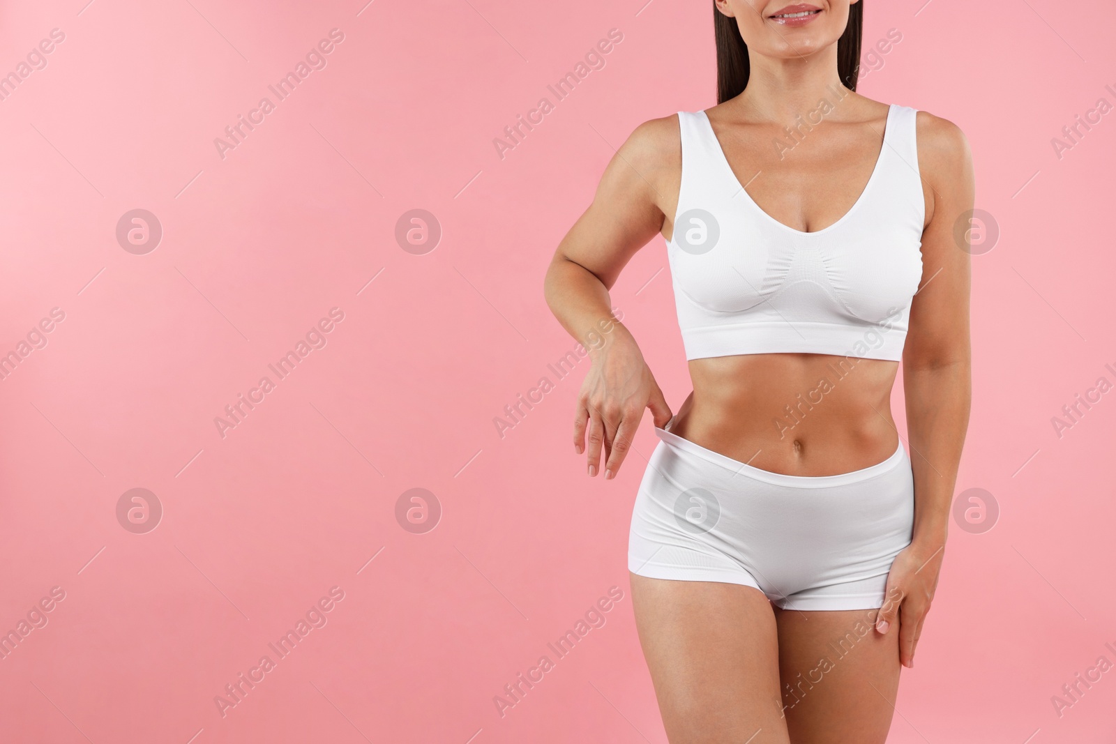 Fit woman with perfect body on pink background, closeup. Space for text Photo of Fit woman with perfect body on pink background, closeup. Space for text