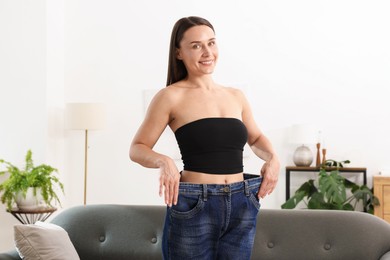 Photo of Fit woman wearing old jeans after weight loss at home