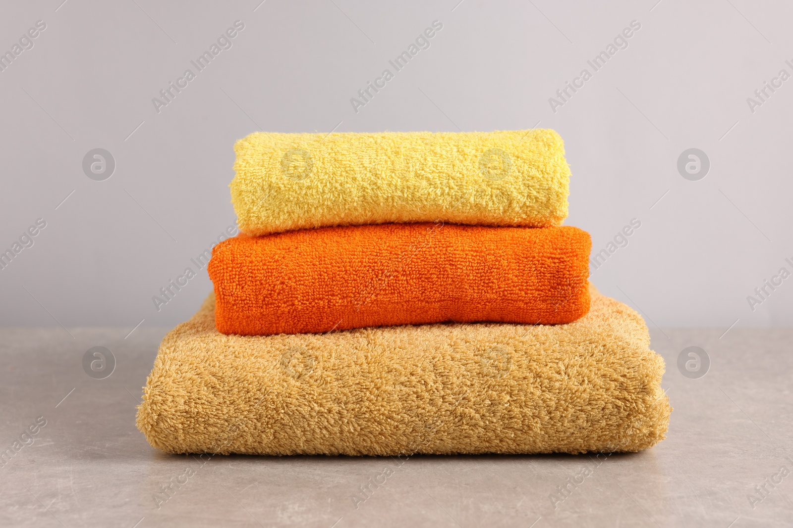 Stack of colorful towels on grey table, closeup Photo of Stack of colorful towels on grey table, closeup