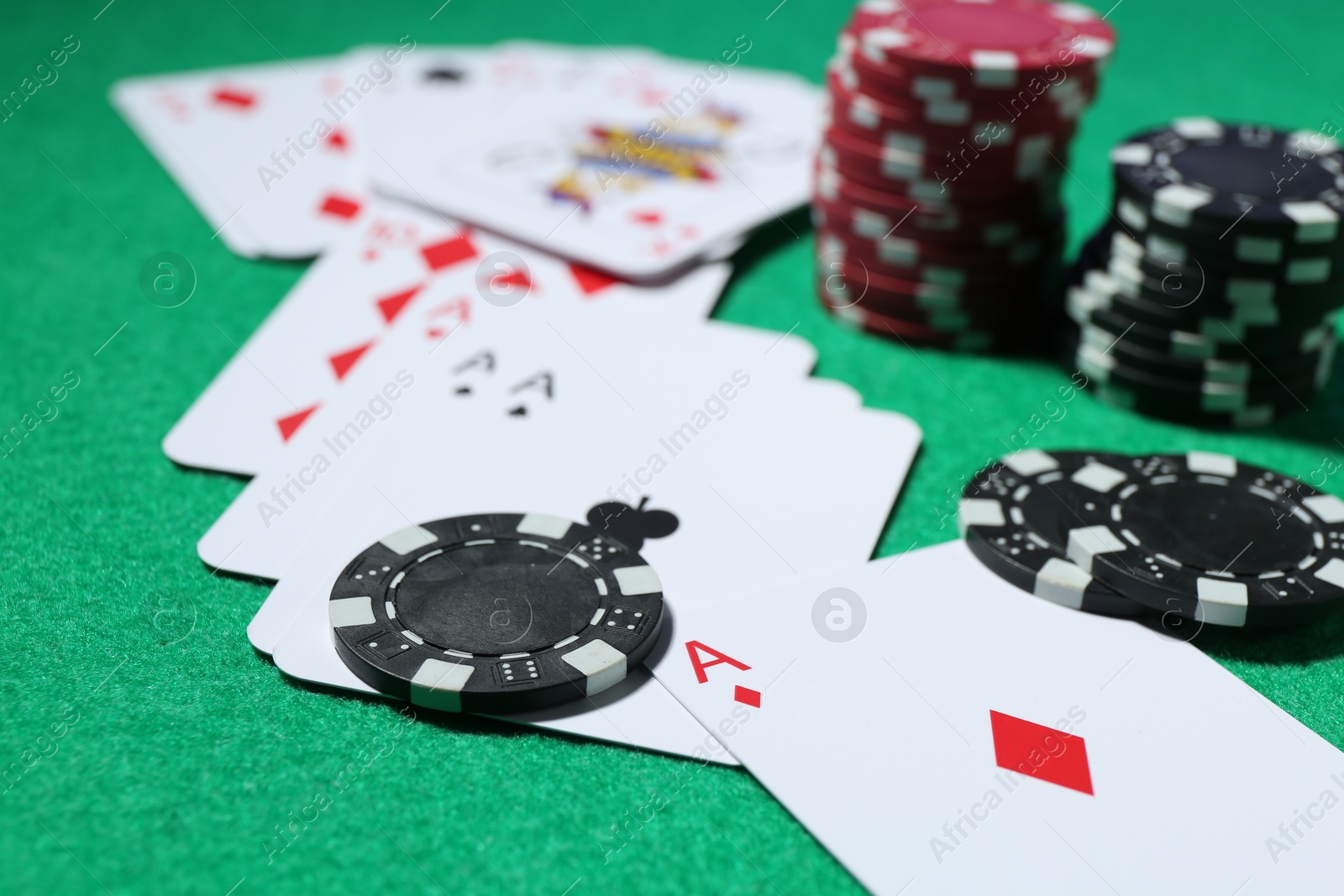 Casino chips and playing cards on green table, closeup Photo of Casino chips and playing cards on green table, closeup