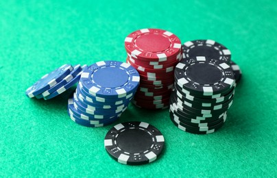 Photo of Stacks of casino chips on green table, closeup