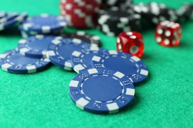 Photo of Casino chips and dice on green table, closeup