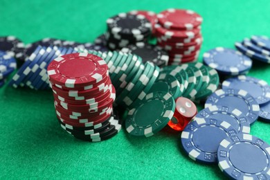 Photo of Casino chips and die on green table, closeup
