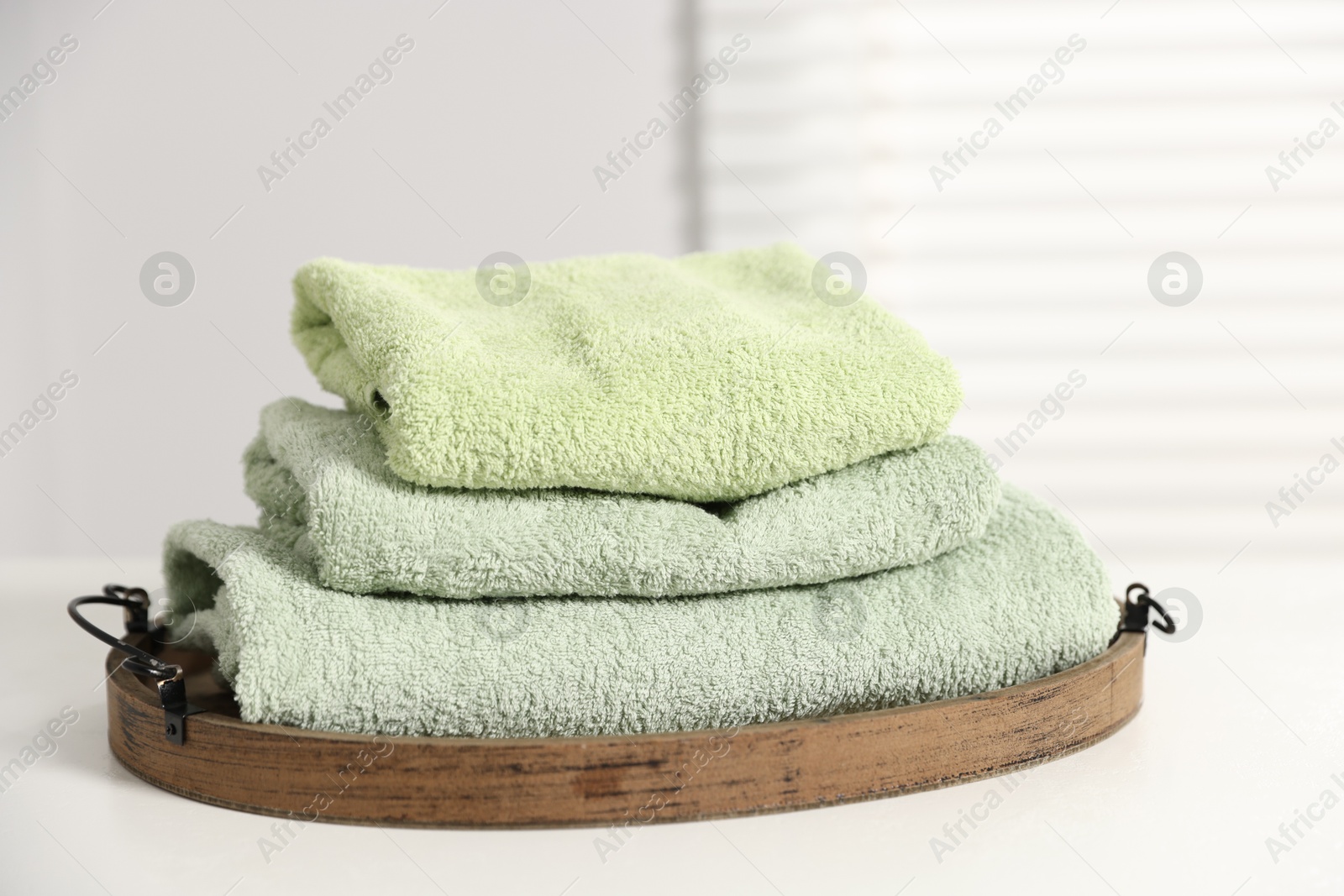 Fresh terry towels on white table in bathroom Photo of Fresh terry towels on white table in bathroom