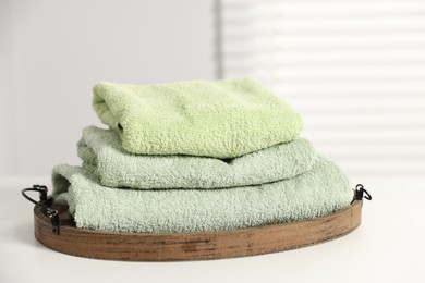 Photo of Fresh terry towels on white table in bathroom