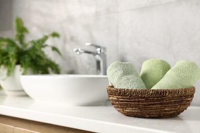 Photo of Fresh terry towels near sink in bathroom