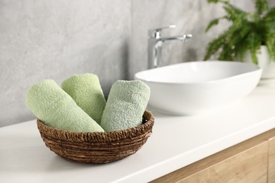 Photo of Fresh terry towels near sink in bathroom