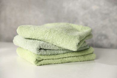 Photo of Fresh terry towels on white table, closeup