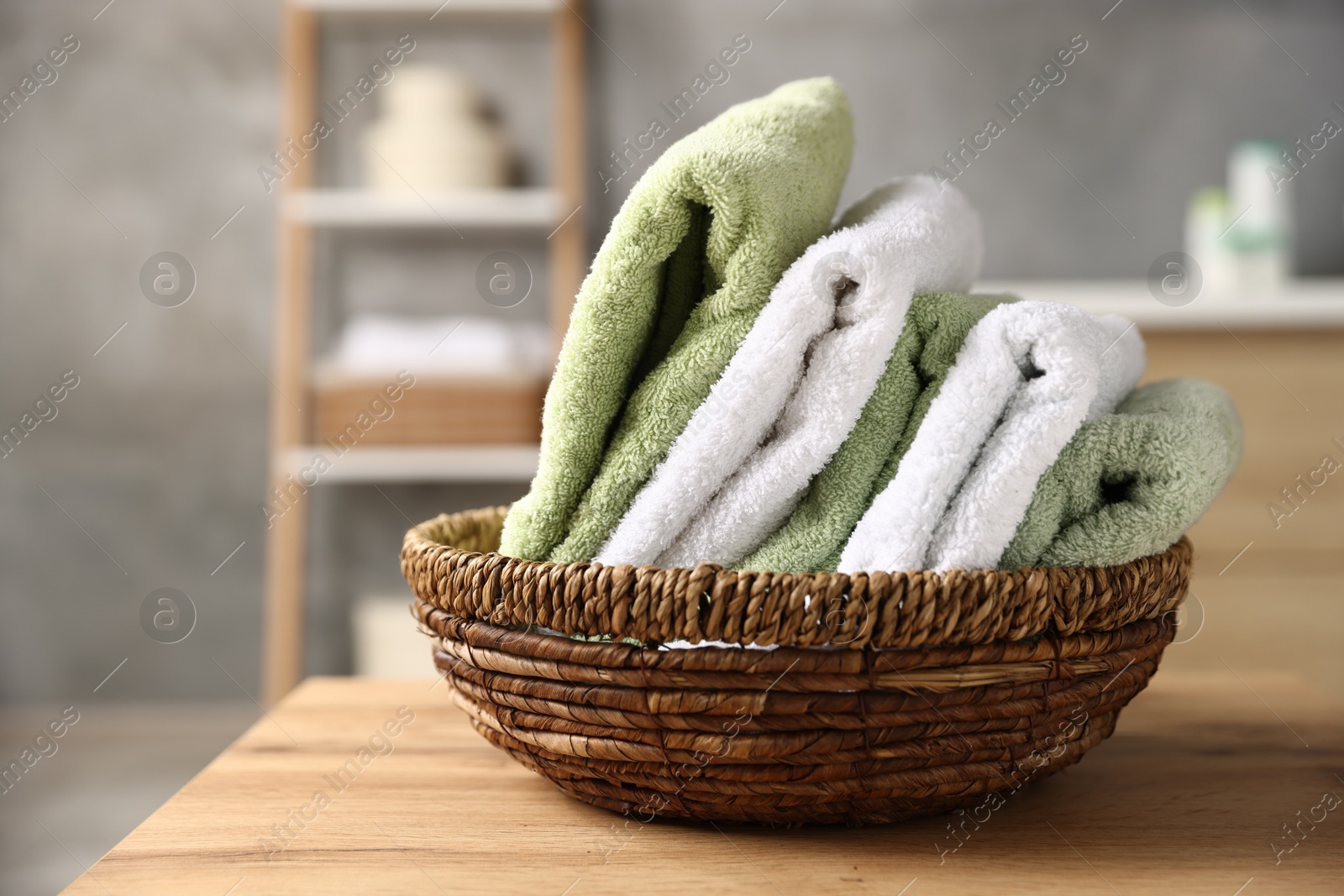 Fresh terry towels on wooden table in bathroom, closeup Photo of Fresh terry towels on wooden table in bathroom, closeup