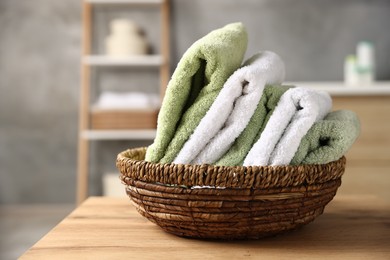 Photo of Fresh terry towels on wooden table in bathroom, closeup