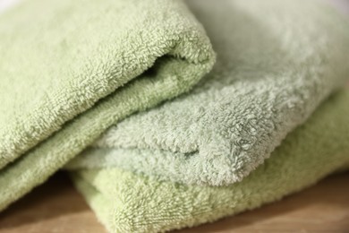 Photo of Fresh terry towels on wooden table, closeup