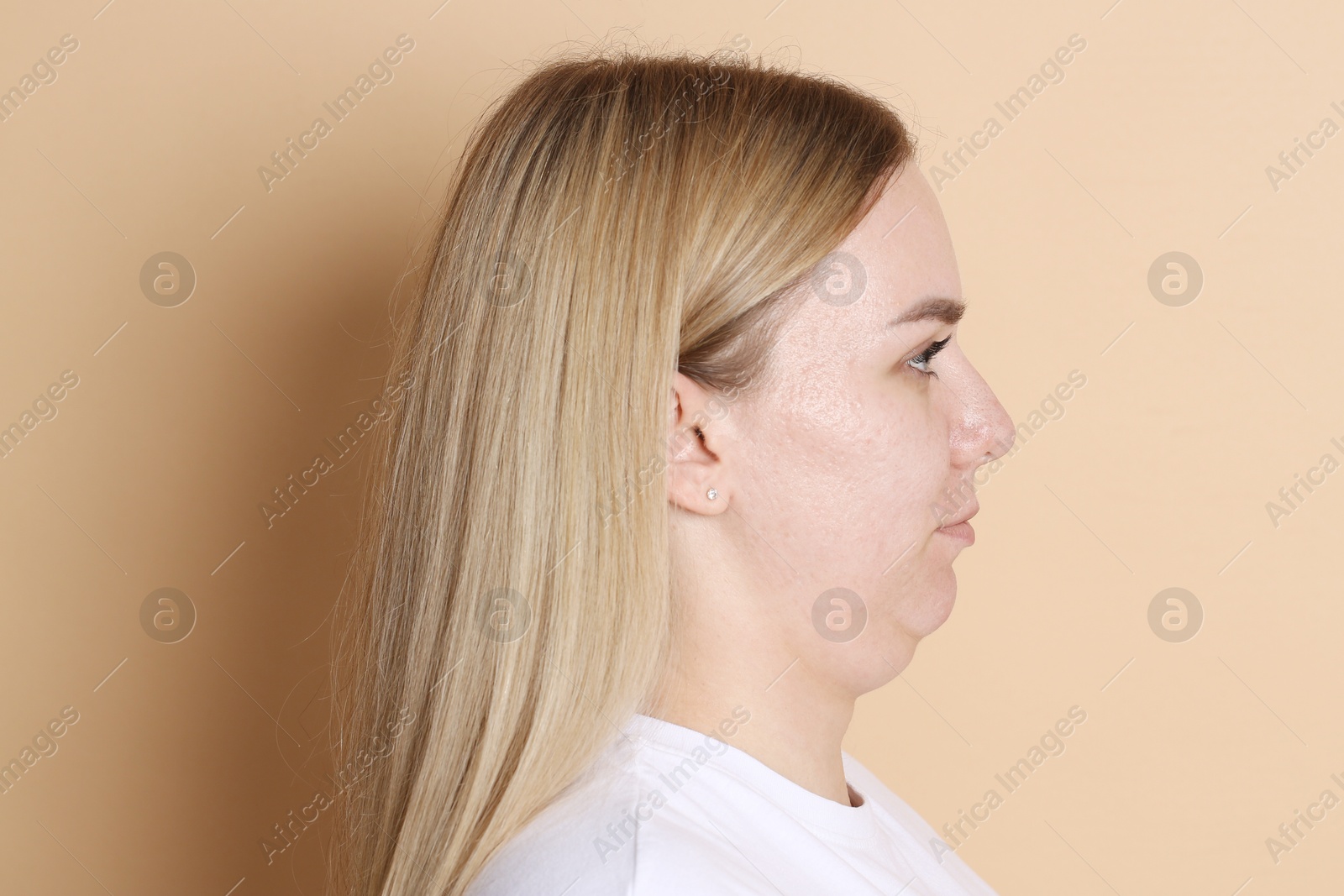 Woman with double chin on beige background Photo of Woman with double chin on beige background