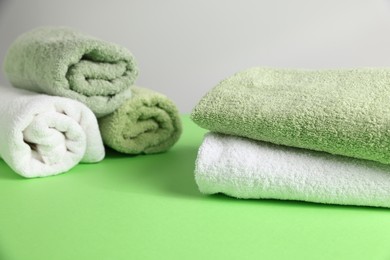 Photo of Fresh terry towels on green table, closeup