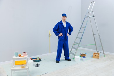 Photo of Worker, ladder and renovation equipment in room