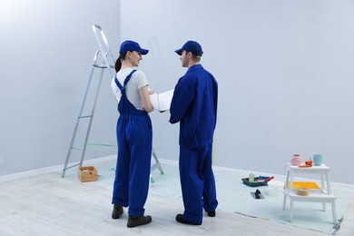 Photo of Workers looking at design project in room, back view