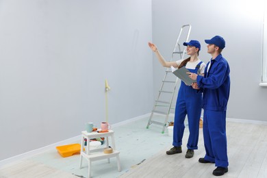 Photo of Workers looking at design project in room. Space for text