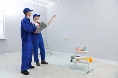 Photo of Workers looking at design project in room. Space for text