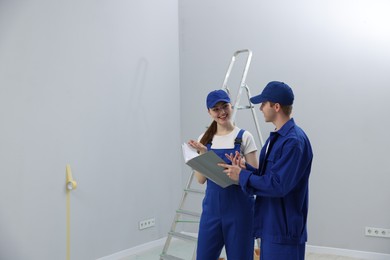 Photo of Workers looking at design project in room. Space for text
