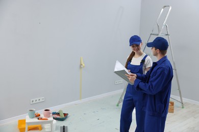 Photo of Workers looking at design project in room. Space for text