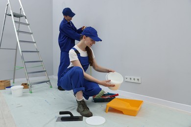 Photo of Workers with different equipment doing renovation in room. Space for text