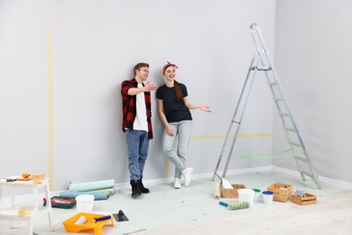 Photo of Happy couple discussing renovation plans in room