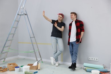 Photo of Happy couple discussing renovation plans in room