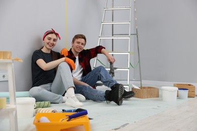 Photo of Couple having break during renovation in room