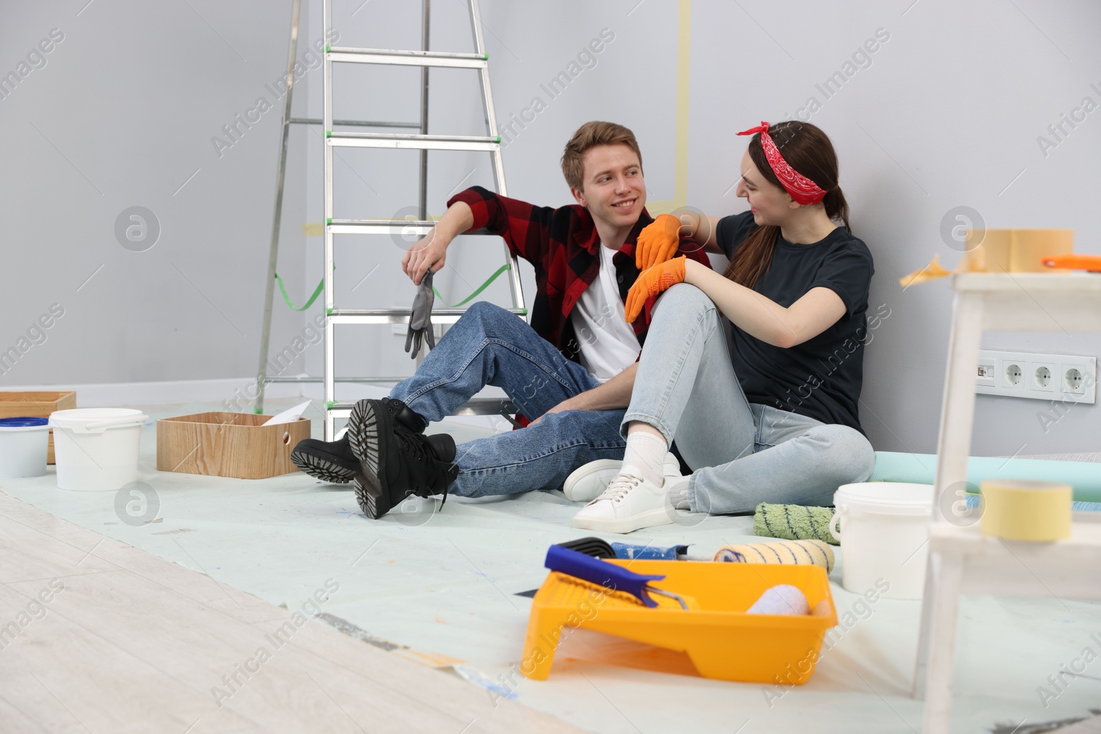 Couple having break during renovation in room Photo of Couple having break during renovation in room