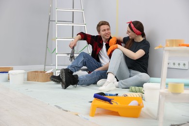 Photo of Couple having break during renovation in room