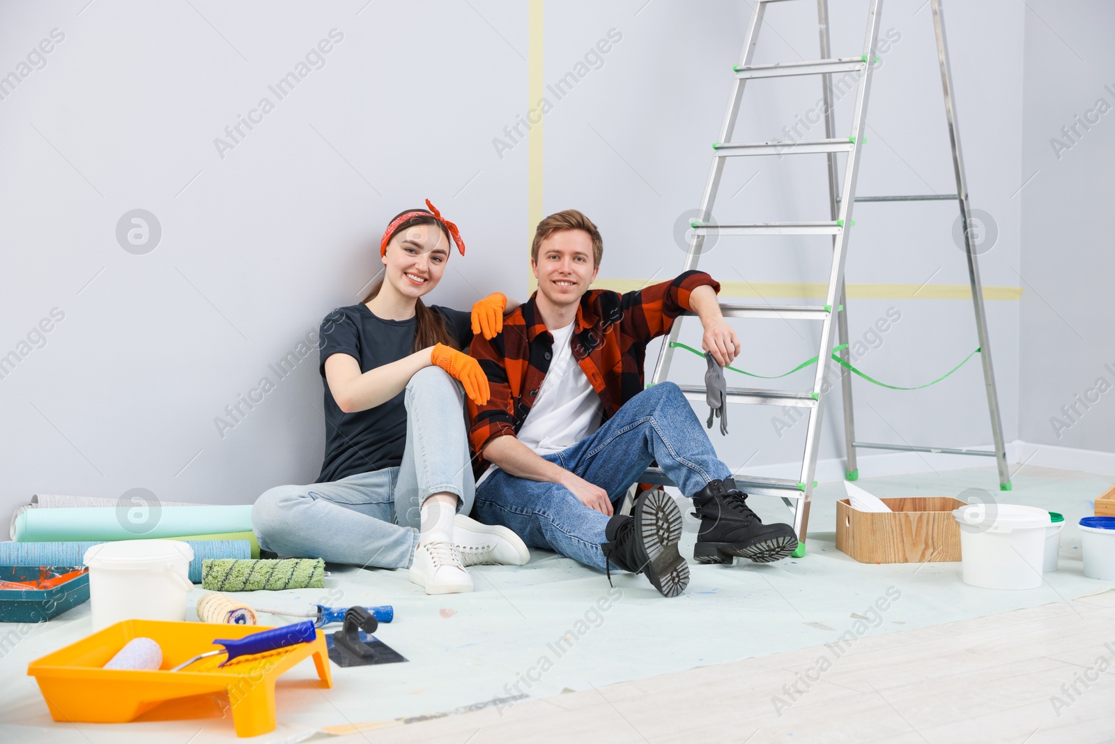 Couple having break during renovation in room Photo of Couple having break during renovation in room