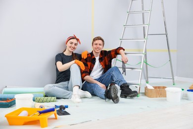 Photo of Couple having break during renovation in room