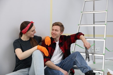 Photo of Couple having break during renovation in room