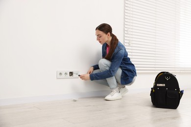 Photo of Woman with screwdriver installing new socket at home