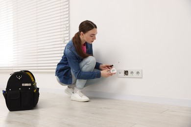 Photo of Woman with screwdriver installing new socket at home