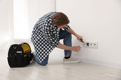 Photo of Man with tools installing new socket at home