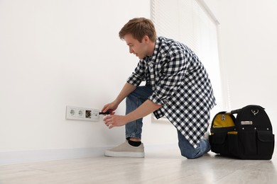 Photo of Man with tools installing new socket at home